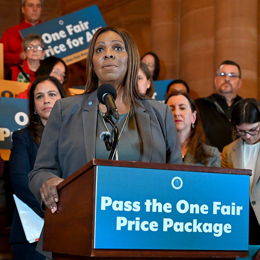AG James at a podium with people behind her